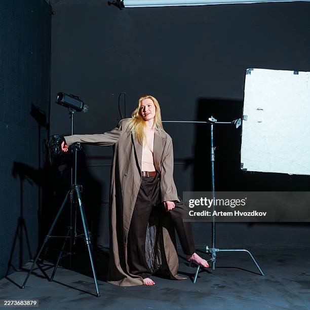 high fashion blonde model posing with professional studio lighting equipment - behind the scenes stock pictures, royalty-free photos & images
