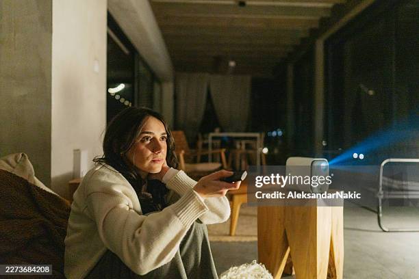 young woman watching movie in home theater - projection equipment stock pictures, royalty-free photos & images
