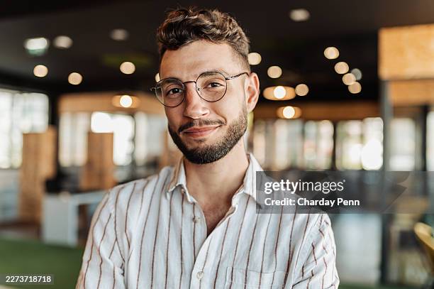jeune entrepreneur confiant travaillant dans un bureau de startup technologique, souriant dans une tenue professionnelle décontractée - sourire narquois photos et images de collection