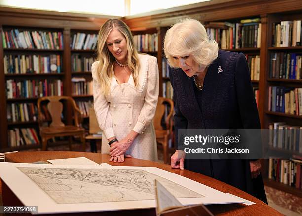 Sarah Jessica Parker and Queen Camilla examine artifacts on display during a literary engagement at New York Public Library on day three of the State...