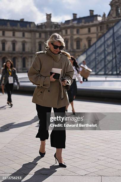 Guest wears black sunglasses, a beige cotton belted trench coat, black slim trousers, black leather pumps shoes, outside Louis Vuitton, during Paris...