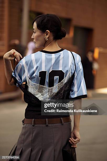 Guest wears grey pleated skirt with a brown leather belt, blue and white stripe football shirt and black and white lace shirt on top during the Visa...