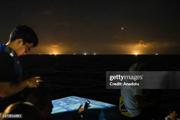 Chinese militia boats with their super flash lights on at night loom in the distance, on Manila-ruled Thitu Island in the disputed South China Sea,...