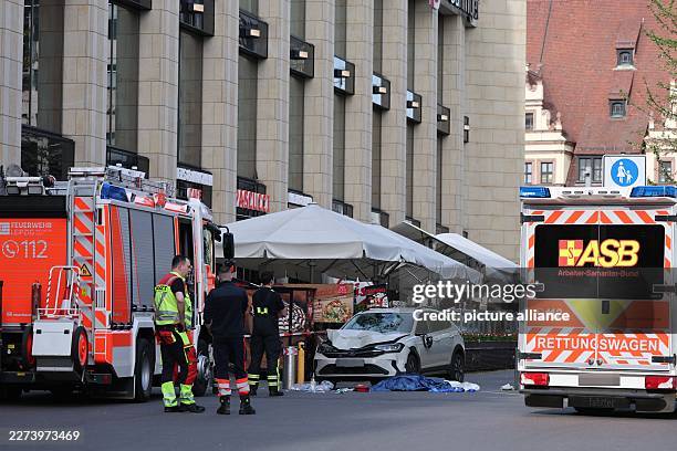 May 2026, Saxony, Leipzig: Rescue workers stand near a damaged car at the spot where a car crashed into a group of people. Photo: Jan Woitas/dpa