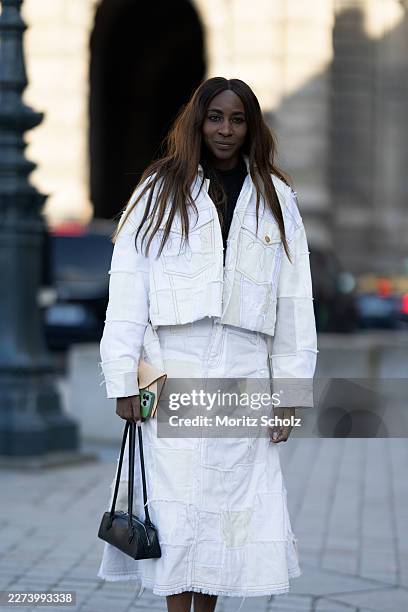Guest is wearing a white cropped denim jacket with cream-colored patches; a black turtleneck sweater; a white A-line denim skirt with cream-colored...