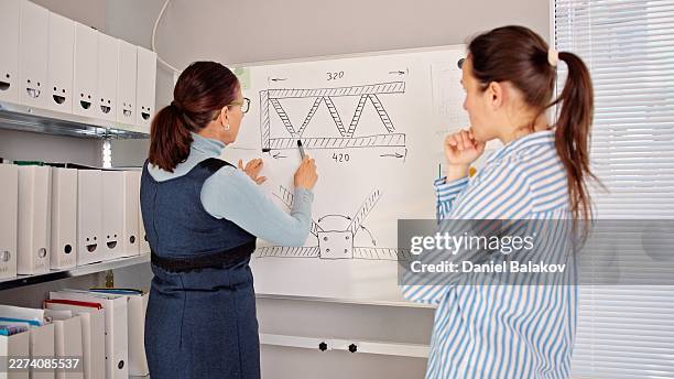teacher explaining engineering concepts drawing on whiteboard - technical college stock pictures, royalty-free photos & images