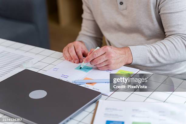 hombre organizando tareas de planificación en la agenda personal - tarea doméstica fotografías e imágenes de stock
