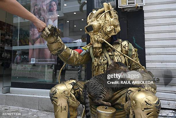 Colombian street artist Oscar Giraldo bumps fists with a passer by as he performs with his pets, a cat called Pereza and a rat called Luciana on a...