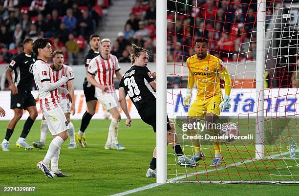 Noah Atubolu of Sport-Club Freiburg fails to save a shot Konstantinos Koulierakis of VfL Wolfsburg , as Patrick Wimmer of VfL Wolfsburg looks on...