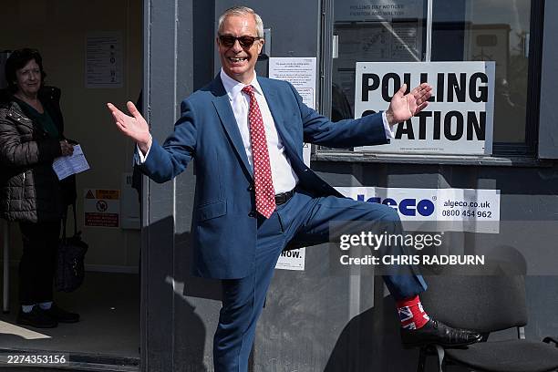 Reform UK leader Nigel Farage poses to show off his socks as he visits a polling station in Walton-on-the-Naze, eastern England on May 7 to cast his...