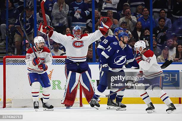 Jakub Dobes, Alexandre Carrier and Kaiden Guhle of the Montréal Canadiens celebrate after defeating the Tampa Bay Lightning 2-1 in Game Seven of the...