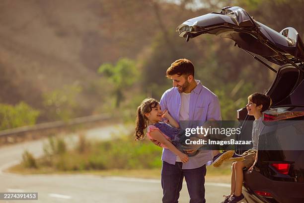 father son and daughter roadside on vacation - straßenrand stock-fotos und bilder