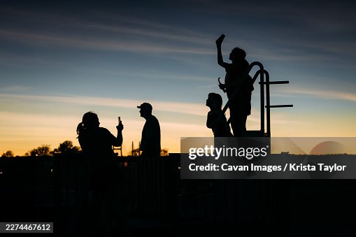 Silhouette of family watching total solar eclipse in sunset Silhouette of family watching total solar eclipse in sunset