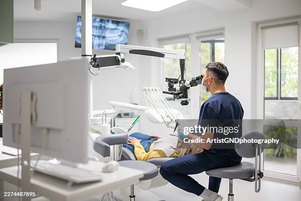 precision dentistry with dental microscope. - implante dentário imagens e fotografias de stock