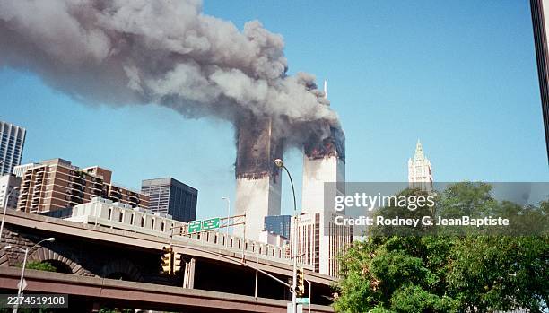 View, from the intersection of Pearl Street & Robert F Wagner Sr Place, of smoke and flames from the World Trade Center towers in the wake of the...