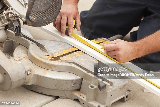 contractor measuring for circular saw cutting of new baseboard renovation - baseboard stock pictures, royalty-free photos & images