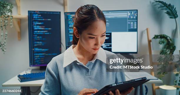 asian female computer programmer uses a digital tablet to check coding while working in home office. software development, digital transformation, tech expertise, artificial intelligence concept. - java code stock pictures, royalty-free photos & images