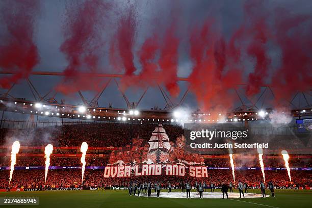 General view inside the stadium during a pyrotechnic display as a tifo depicting multiple ships with the text "Over Land And Sea" is displayed prior...