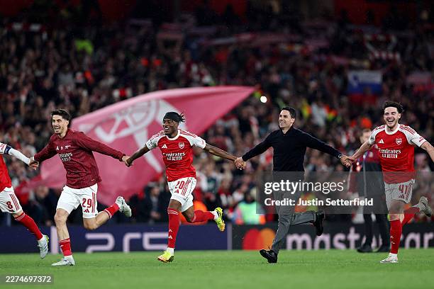 Mikel Arteta, Manager of Arsenal, celebrates progressing to the final of the UEFA Champions League 2025/26 with Kai Havertz, Noni Madueke and Declan...