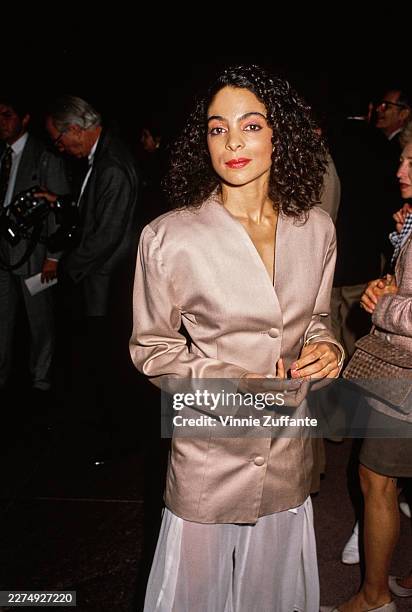 American actress and singer Jasmine Guy, wearing a champagne-coloured jacket with a white skirt, attends the West Hollywood premiere of 'A Dry White...