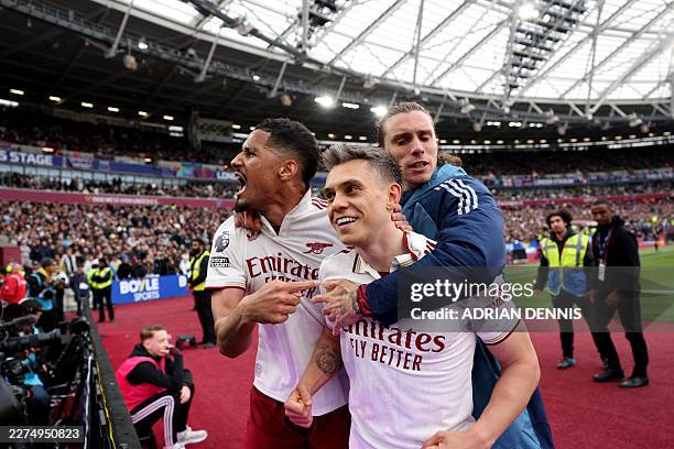 Arsenal's Belgian midfielder Leandro Trossard celebrates scoring the team's first goal with Arsenal's Italian defender Riccardo Calafiori and...
