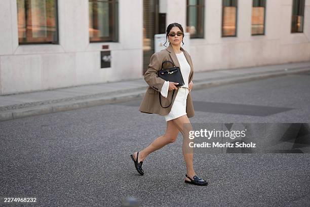 Aylin Sengül is seen wearing a desert taupe oversized boyfriend blazer with structured shoulders, notch lapels, flap pockets and a two button front...
