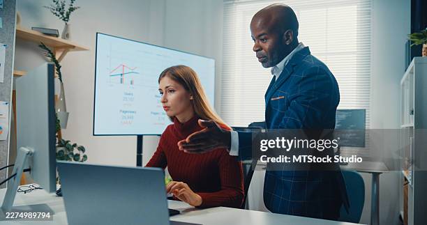 black male manager teaches young white female computer programmer writing code in the corporate office. partnership teamwork planning, artificial intelligence development, innovation concepts. - programmer working stock pictures, royalty-free photos & images