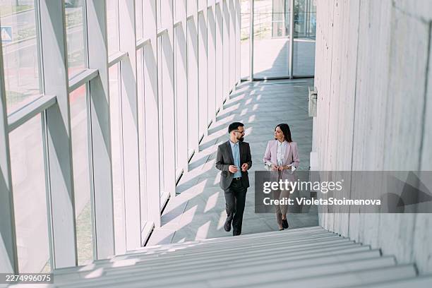 business colleagues talking on stairs in the office. - business talk stock pictures, royalty-free photos & images