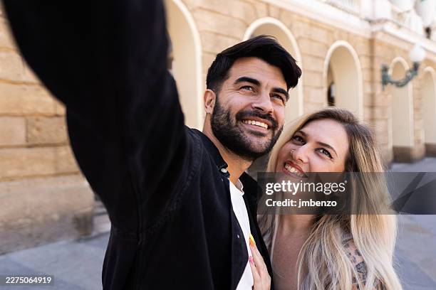 happy couple taking selfie while traveling in city - historic building stock pictures, royalty-free photos & images