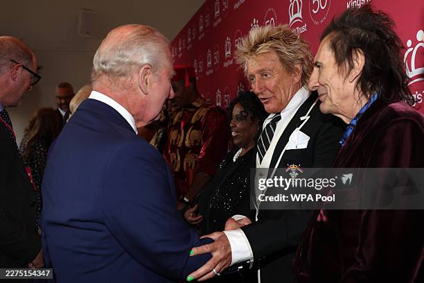 Britain's King Charles III speaks with British rock legends Rod Stewart and Ronnie Wood as he arrives to attend 'A King's Trust 50th Anniversary...