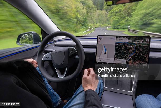 May 2026, Rhineland-Palatinate, Gerolstein: A self-driving Tesla Model Y is driving autonomously on the roads of the Eifel. A factory driver sitting...