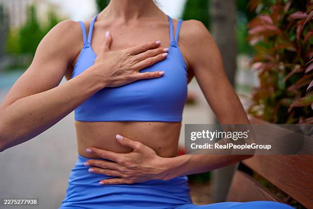 woman practicing deep breathing exercise for mindfulness and relaxation - belly breathing stock pictures, royalty-free photos & images
