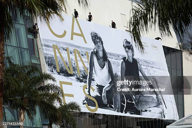 Workers install the official 2026 festival poster, featuring an image of Susan Sarandon and Geena Davis in "Thelma & Louise", during the 79th annual...