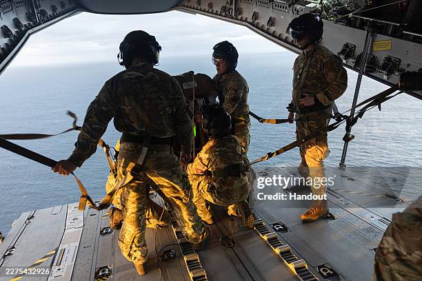 In this handout image provided by the UK Ministry of Defence, British Army paratroopers aboard an RAF A400 prepare for a drop onto the remote...