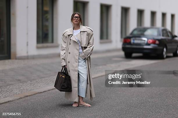 Sophia Geiss seen wearing an oversized cream H&M x Stella McCartney trench coat paired with layered Drykorn shorts and Zara jeans, a brown Hermès...