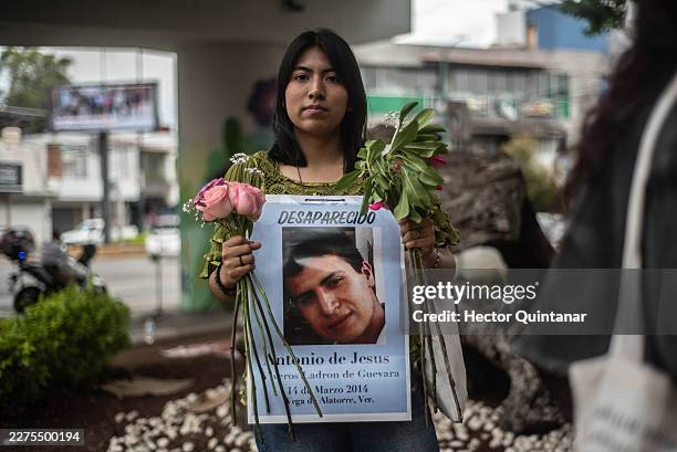 Woman poses with the portrait and missing person poster of a missing person during a protest to demand justice for the disappeared in Mexico on May...