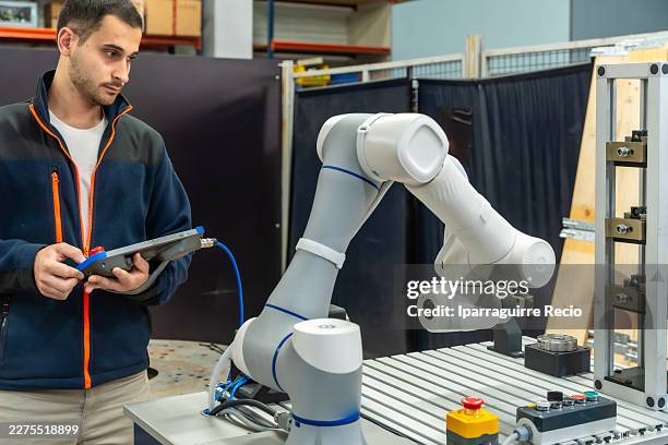 engineer programming robotic arm with control panel - computer vision stock pictures, royalty-free photos & images