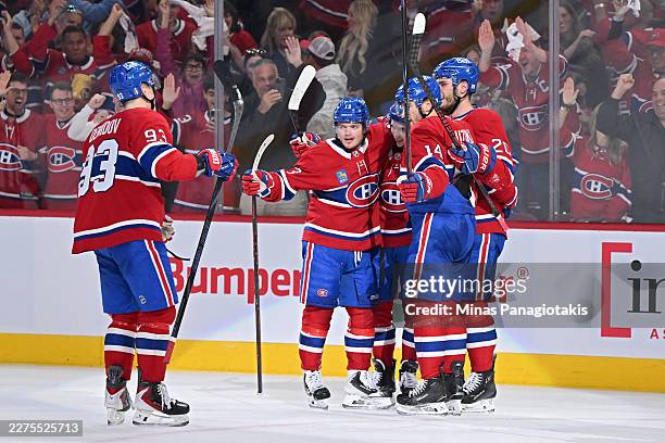 Cole Caufield of the Montreal Canadiens celebrates with teammates after scoring a goal against the Buffalo Sabres during the second period in Game...