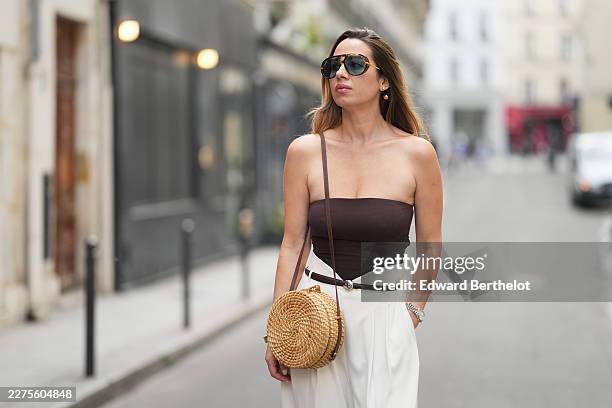 Maria Rosaria Rizzo wears long straight brown hair with lighter ends and a side part, black oversized Bottega Veneta sunglasses with dark lenses and...