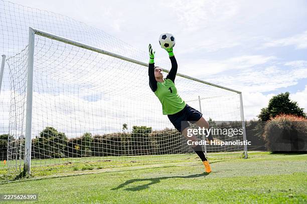 female goalkeeper grabbing a ball in the air - diving to the ground stock pictures, royalty-free photos & images