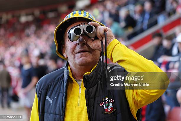 Southampton fan is seen using binoculars inside the stadium prior to during the Sky Bet Championship Play Off Semi Final Second Leg match between...