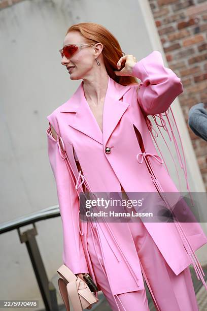 Vera Blue wearing pink Karla Spetic suit, red tinted sunglasses, pink-beige shoulder bag at Australian Fashion Week 2026 at St Barnabis Angelican...