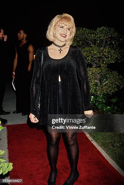 American actress and singer Tina Yothers, wearing a black dress with a choker-style necklace and crucifix pendant, attends the 2nd Annual 'Laughing...