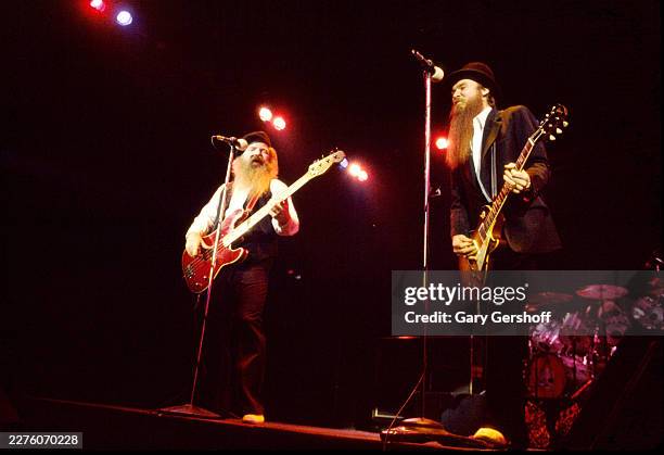 American Rock musicians Dusty Hill , on bass guitar, and Billy Gibbons, on electric guitar, both of the group ZZ Top, perform onstage at Nassau...