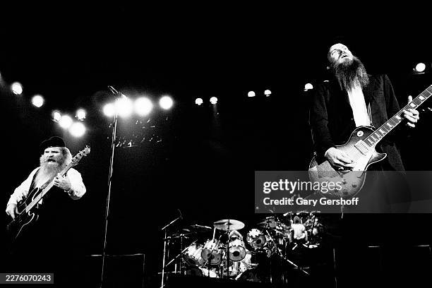 American Rock musicians Dusty Hill , on bass guitar, and Billy Gibbons, on electric guitar, both of the group ZZ Top, perform onstage at Nassau...