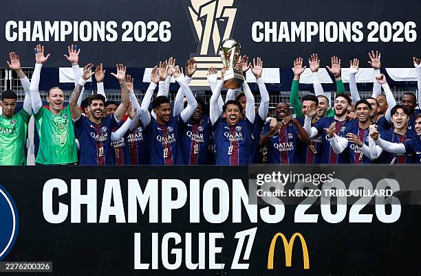 Paris Saint-Germain's Brazilian defender Marquinhos lifts the French Ligue 1 trophy as he celebrates alongside teammates after winning the...