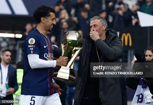 Paris Saint-Germain's Brazilian defender Marquinhos and Paris Saint-Germain's Spanish head coach Luis Enrique celebrate with the French Ligue 1...