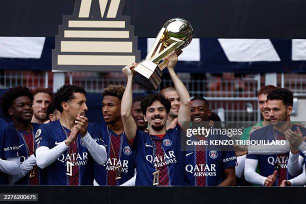 Paris Saint-Germain's Portuguese midfielder Vitinha lifts the French Ligue 1 trophy as he celebrates alongside teammates after winning the...