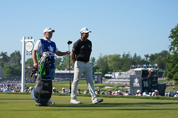 Aaron Rai of England stands with his caddie, Jason Timmis, on the 15th tee box, during the final round of PGA Championship at Aronimink Golf Club on...