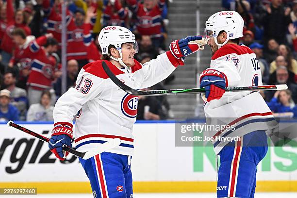 Cole Caufield celebrates with Nick Suzuki of the Montréal Canadiens after scoring a goal against the Buffalo Sabres during the first period in Game...